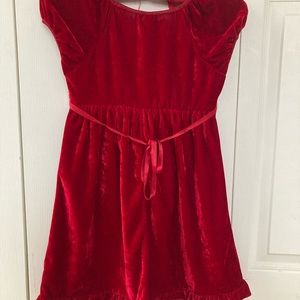 Red color, soft to touch, and velvet dress for girls of age 7-8 years.